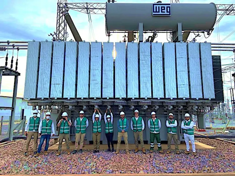 Equipe Bawner diante de banco de transformadores